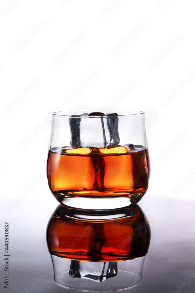 glasses of whiskey with ice cubes on black glass surface glasses of whiskey with ice cubes on black glass surface