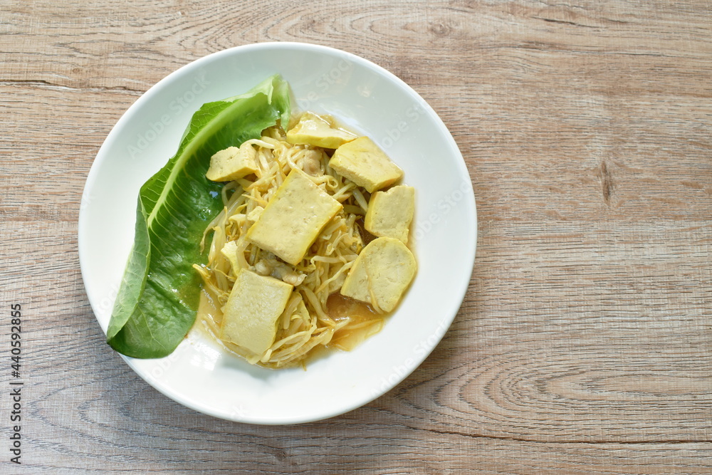 fried bean sprout with slice yellow tofu in plate on table