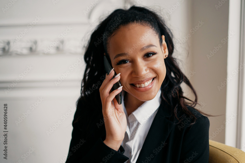 The financier calls the client on the phone. Businesswoman afro smiles manager working on laptop and tablet. The lawyer sits in a modern rented office. The financier calls the client on the phone. Businesswoman afro smiles manager working on laptop and tablet. The lawyer sits in a modern rented office.
