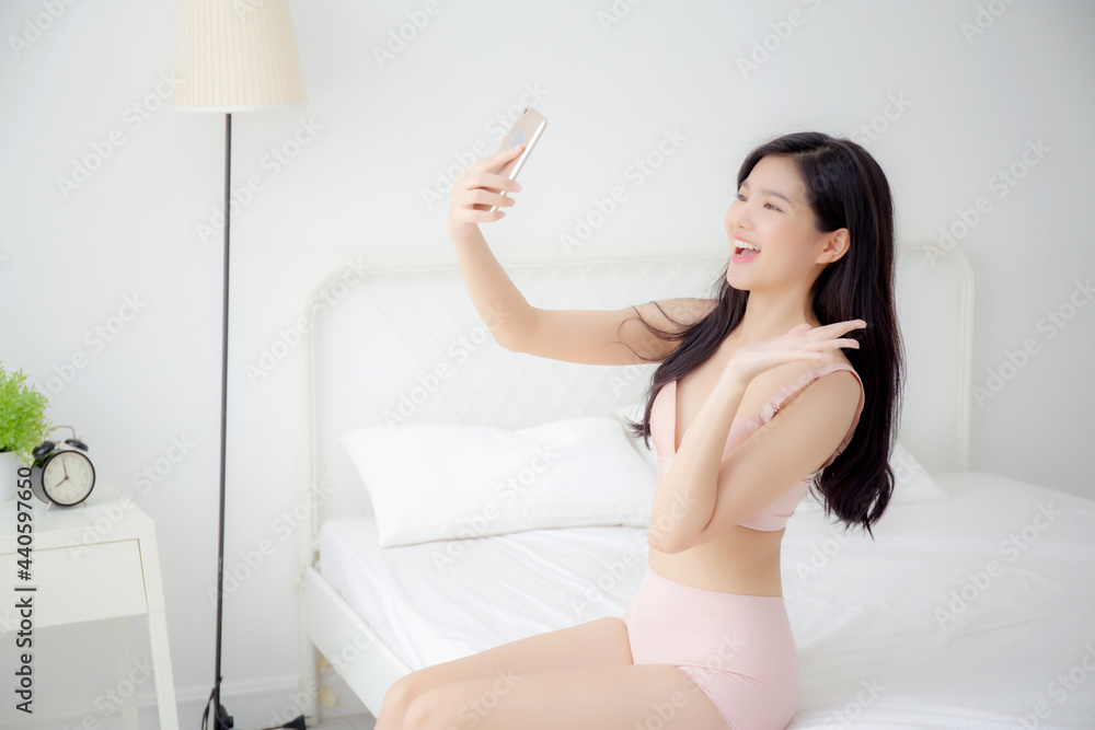 Beautiful young asian woman sexy in underwear talking a selfie on smartphone for social network in the bedroom, girl in lingerie relax with taking a picture on mobile phone on bed in the bedchamber. Beautiful young asian woman sexy in underwear talking a selfie on smartphone for social network in the bedroom, girl in lingerie relax with taking a picture on mobile phone on bed in the bedchamber.
