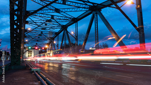 Light trails from cars run across the bridge at dusk, at twilight time, traffic is chaotic.