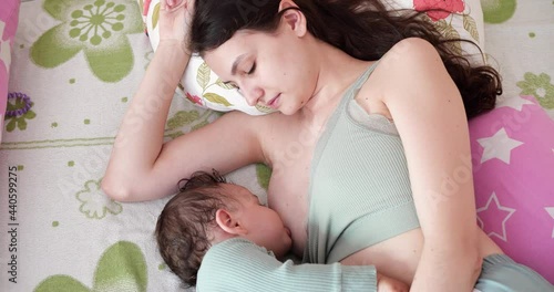 Mother breastfeeding her newborn baby on sofa. Milk from mother's breast is a natural medicine to baby. family, food, child, eating and parenthood concept photo