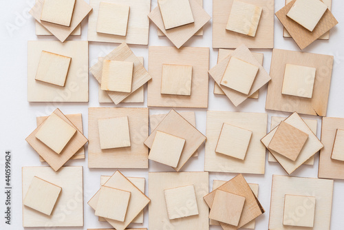 laser cut untreated or natural square wooden shapes arranged on a light background - photographed from above in a flat lay style with ambient light