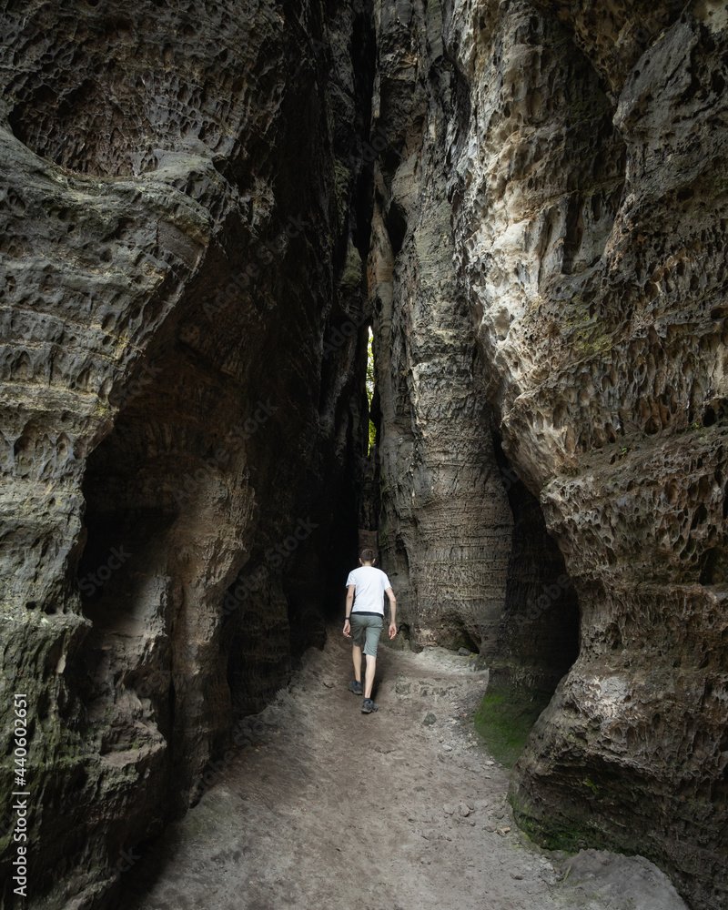 Adult male tourist walking at sandstone rock formations in Tisá, Czech republic. Film location of The Chronicles of Narnia