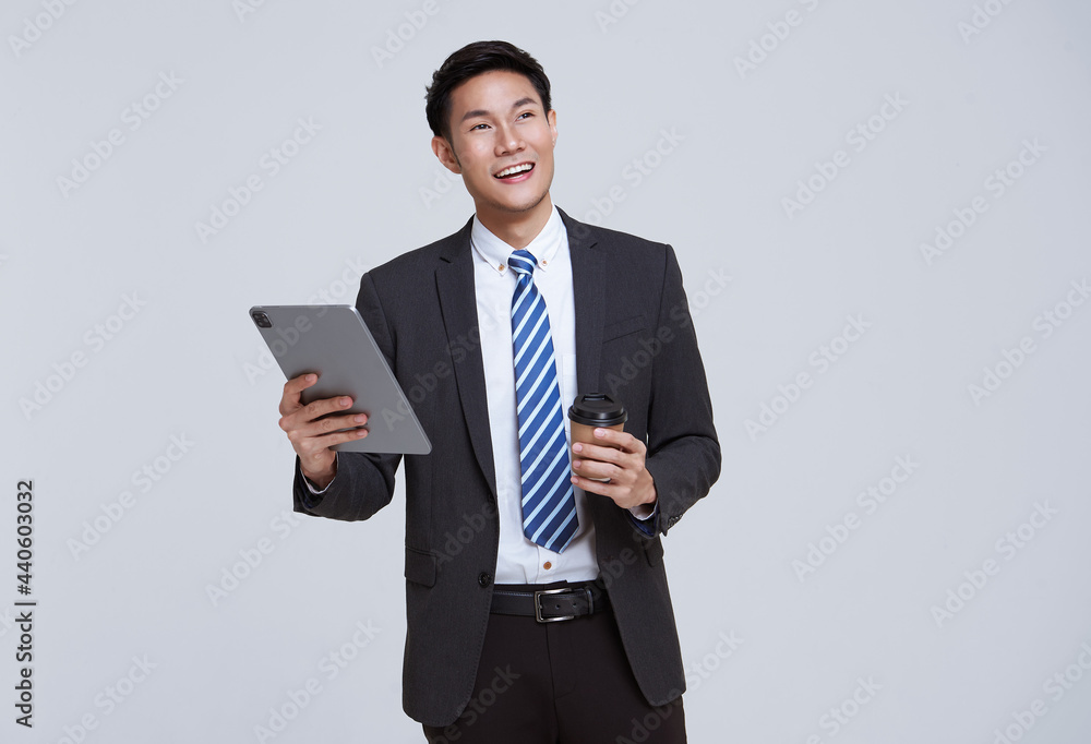 Handsome and friendly face asian businessman smile in formal suit his using tablet on white background studio shot. Handsome and friendly face asian businessman smile in formal suit his using tablet on white background studio shot.