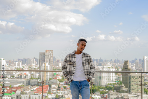 Portrait of African black man outdoors in city at rooftop during summer
