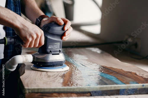 Valokuva Man is processing with wood by polishing machine