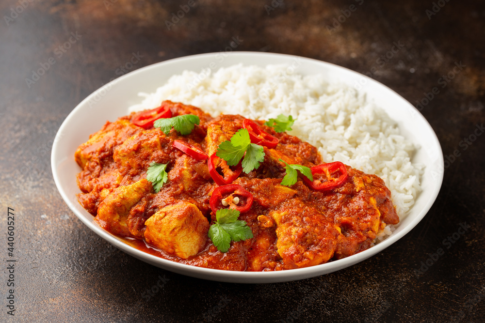 Spicy Chicken Pathia curry with basmati rice in a white plate. healthy food. Spicy Chicken Pathia curry with basmati rice in a white plate. healthy food.