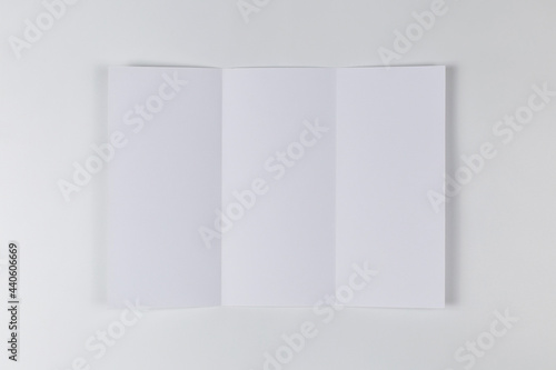 Fototapeta Naklejka Na Ścianę i Meble -  Empty sheet of paper folded three times on white background. Top view