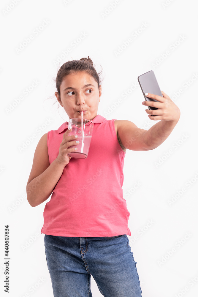 Focused little girl drinking and taking a photo of herself Focused little girl drinking and taking a photo of herself