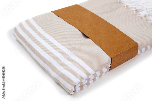 Beige and striped Peshtemal Turkish towel folded colorful textile for spa, beach, pool, light travel, healthy fashion and gifts. Traditional turkish bath material