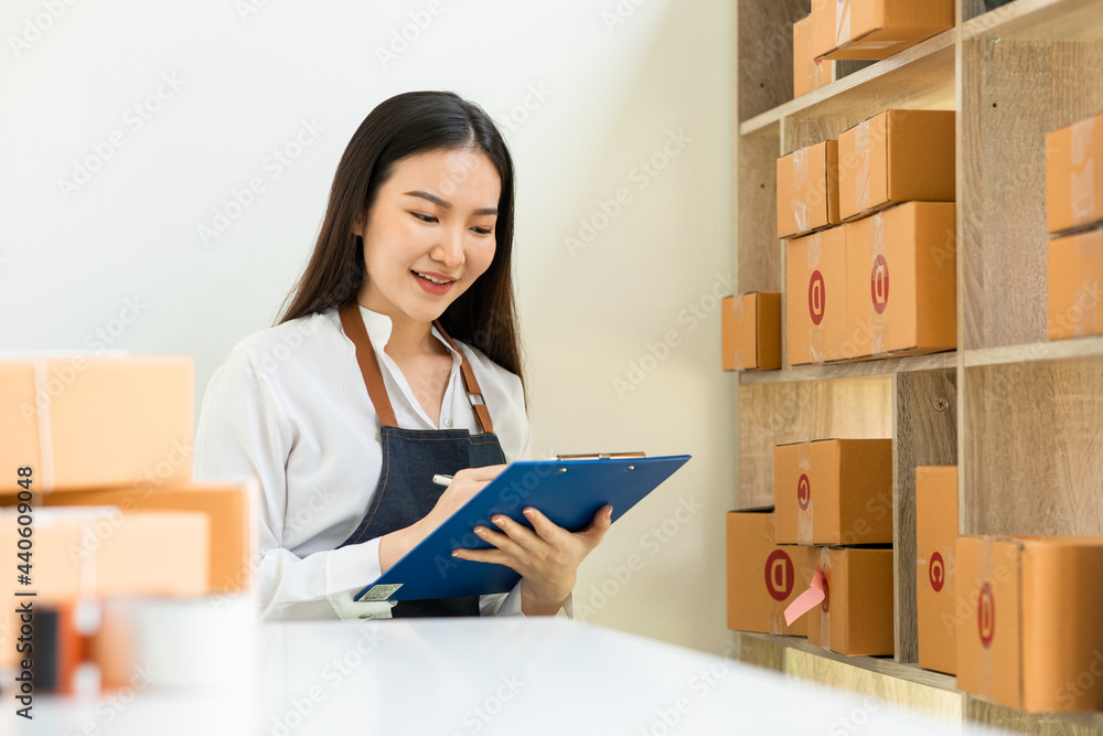 Portrait of Starting small businesses SME owners female entrepreneurs working on receipt box and check online orders to prepare to pack the boxes, sell to customers, sme business ideas online. Portrait of Starting small businesses SME owners female entrepreneurs working on receipt box and check online orders to prepare to pack the boxes, sell to customers, sme business ideas online.