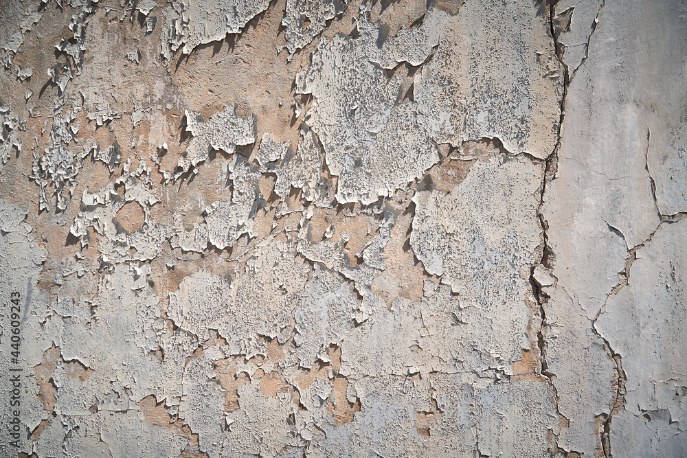 old peeling plaster on the wall in the bright sunlight on the side old peeling plaster on the wall in the bright sunlight on the side