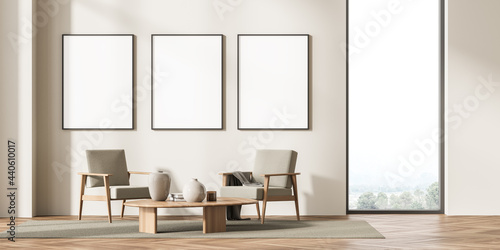 Three framed mockup posters in villa living room design interior, beige furniture on bright wall, wood floor, Two armchairs. Concept of relax. © ImageFlow