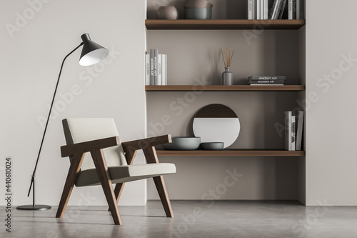 Minimalist living room interior with armchair and bookshelf on grey floor