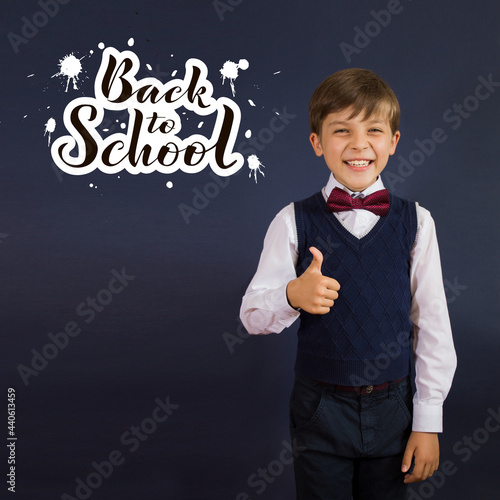 Close-up of a smiling, laughing, happy, funny teenage boy showing thumb up isolated on blue background. lettering Back to school