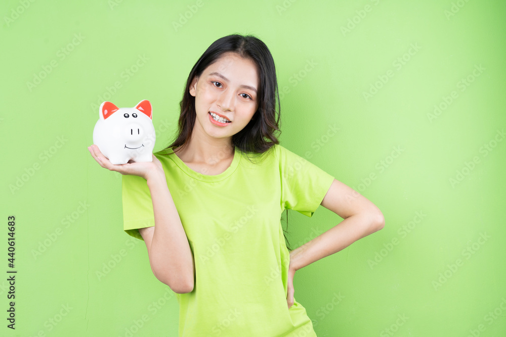 asian girl holding piggy bank in her hand money saving concept asian girl holding piggy bank in her hand money saving concept