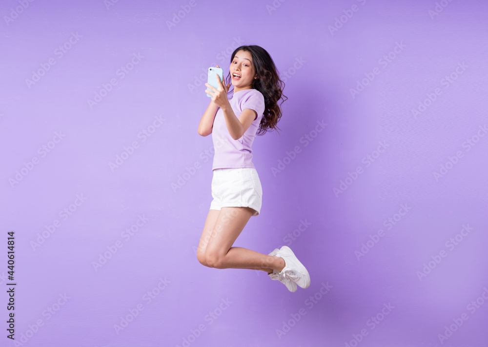 Young asian girl jumping up on purple background Young asian girl jumping up on purple background