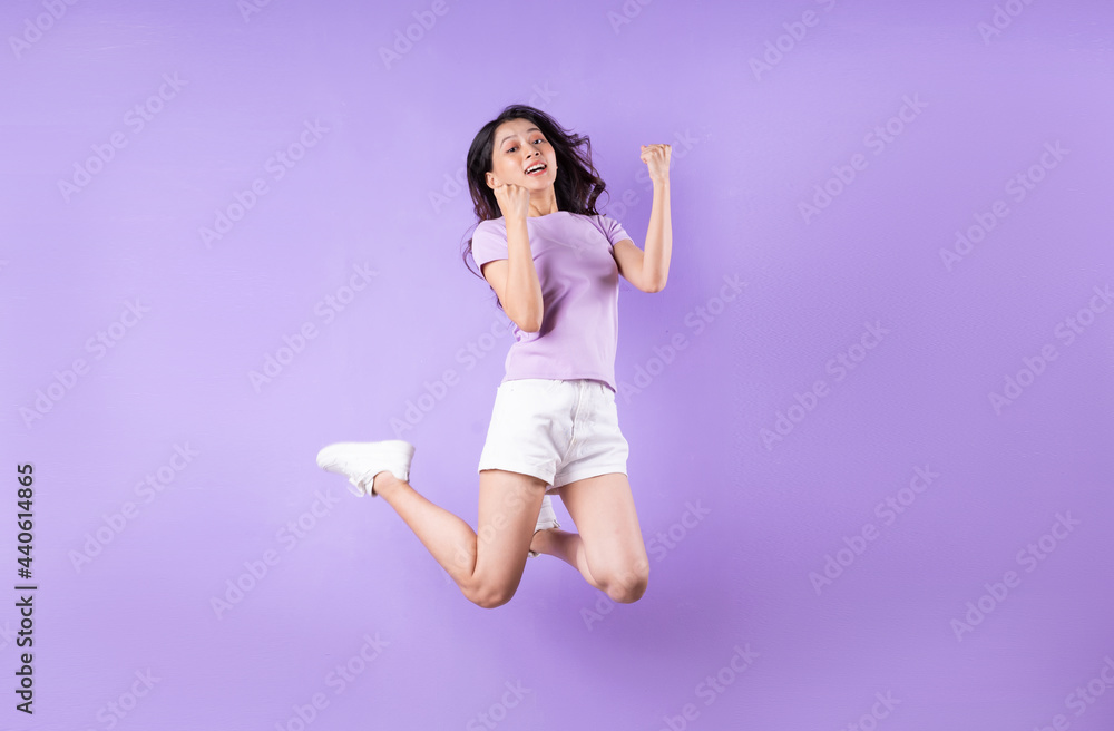 Young asian girl jumping up on purple background Young asian girl jumping up on purple background