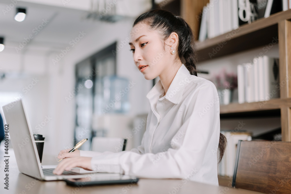 Concentrated young beautiful businesswoman working on laptop in bright modern office,Work from home concept Concentrated young beautiful businesswoman working on laptop in bright modern office,Work from home concept