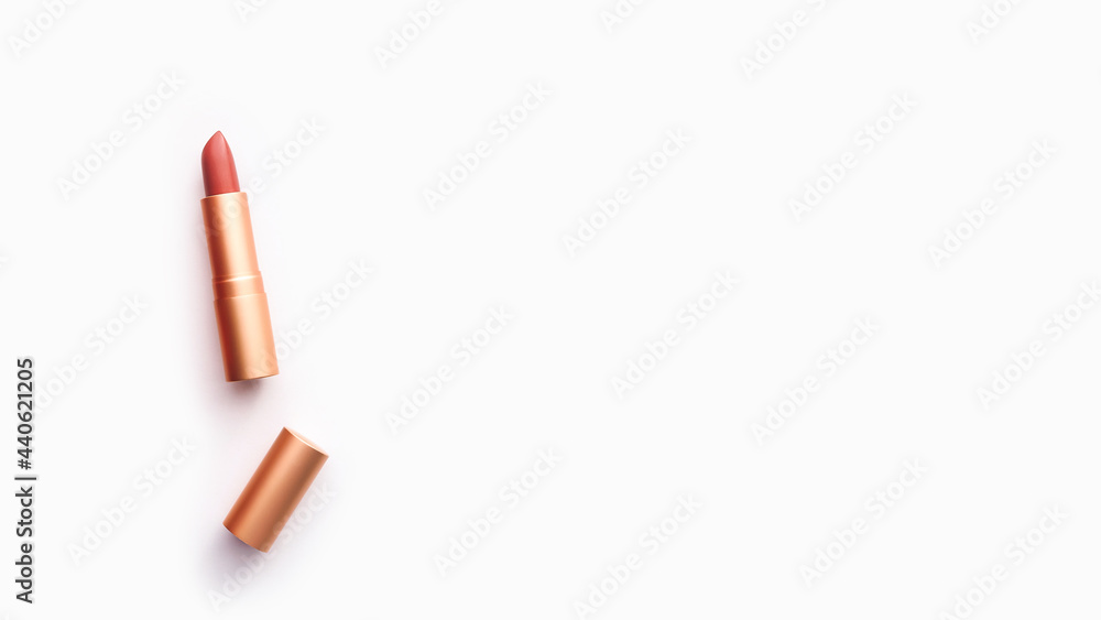 nude lipstick in a golden case on a light background, copy space nude lipstick in a golden case on a light background, copy space