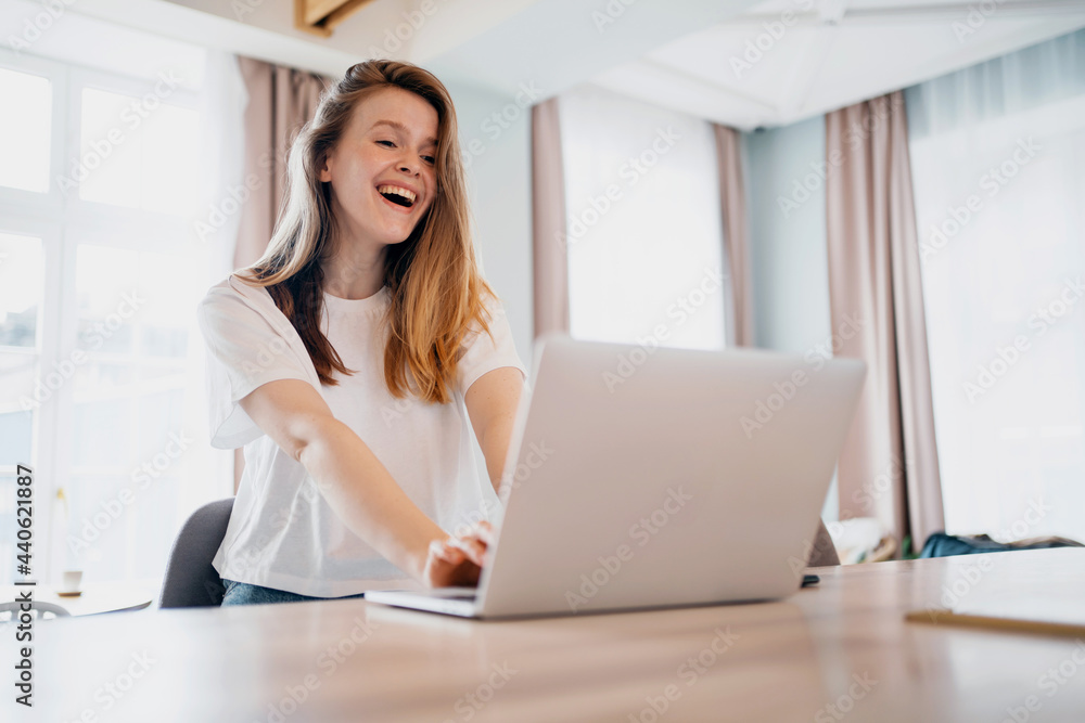 Student learning on a laptop in the living room. A freelancer sits in an apartment and works on a laptop and communicates via video link. Young woman shopping online ordering home groceries. Student learning on a laptop in the living room. A freelancer sits in an apartment and works on a laptop and communicates via video link. Young woman shopping online ordering home groceries.