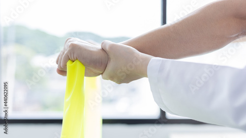 Wallpaper Mural Physical therapy, Female physiotherapist uses an elastic band to test the arm injury of a male patient attending in clinic, Bone arrangement, Non-surgical medical treatment, Medical techniques. Torontodigital.ca