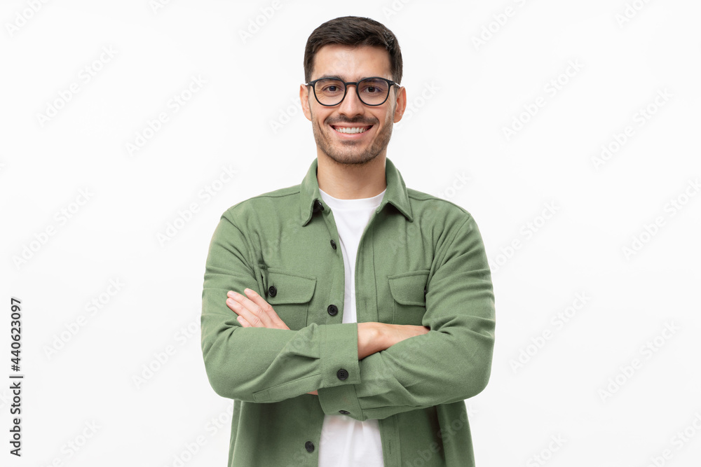 Portrait of young smiling latin man in green shirt and glasses, feeling confident, isolated on gray background Portrait of young smiling latin man in green shirt and glasses, feeling confident, isolated on gray background