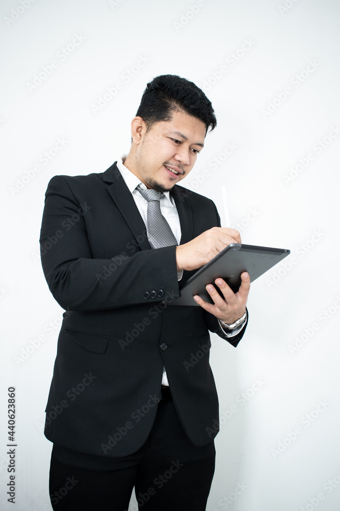 Smiling portrait of businessman with touchscreen tablet device in business suit isolated in studio Smiling portrait of businessman with touchscreen tablet device in business suit isolated in studio