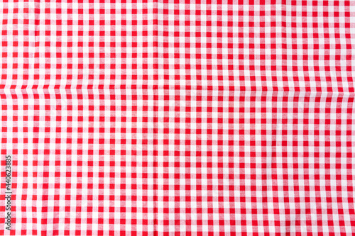 A crumpled dining tablecloth with a white and red checker pattern is the background. Top view for food menu design. Used to cover the dining table to prevent stains, make it easy to clean the table.