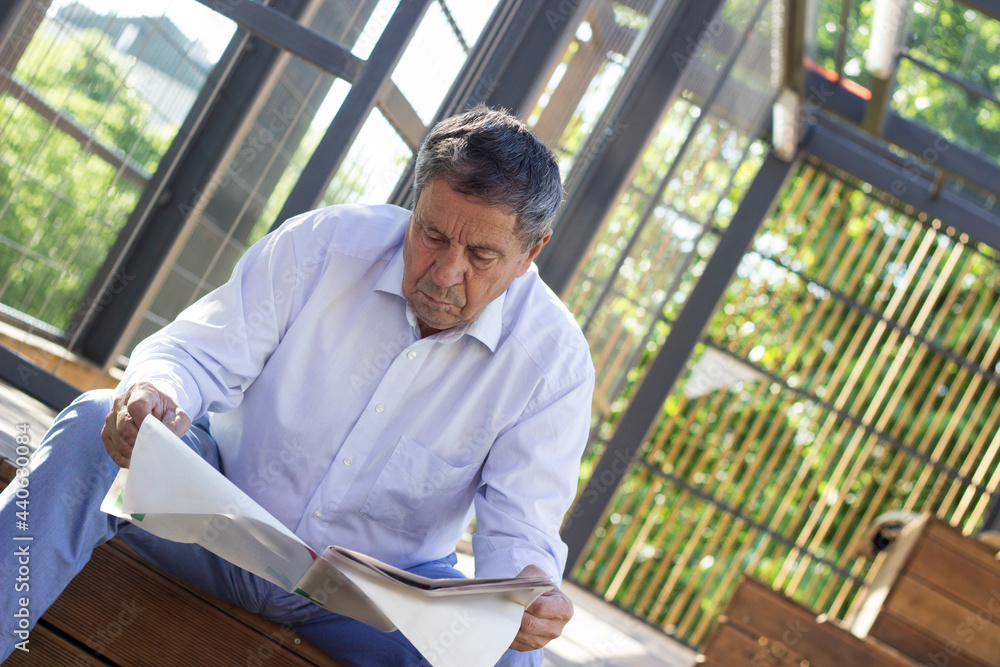 Active senior man reading a newspaper during a relaxing day outdoors