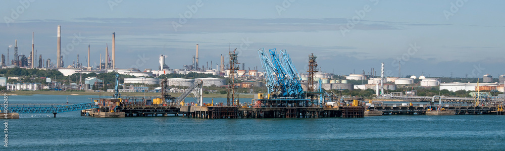 England, UK. 2021. Fuel loading jetty at a refinery with a background of fuel storage tanks. England, UK. 2021. Fuel loading jetty at a refinery with a background of fuel storage tanks.