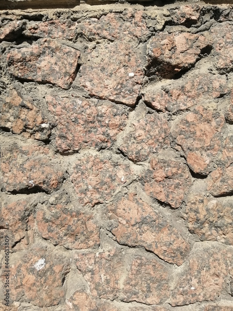 The texture of a stone wall. Background texture of the stone wall of an old gray building. A stone wall as a background or texture.