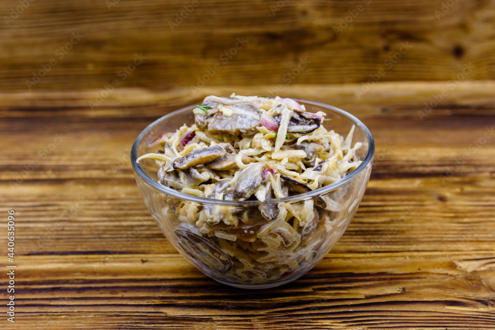 Salad with celery root, roasted mushrooms and onion stuffed with mayonnaise on a wooden table Salad with celery root, roasted mushrooms and onion stuffed with mayonnaise on a wooden table