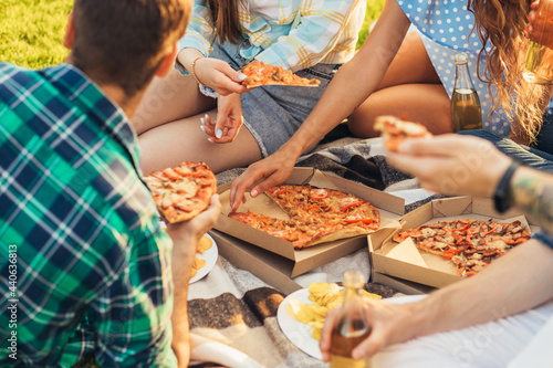Close-up hands take pieces of pizza  Pizza and food concept  Friends on a picnic in nature  having fun and eating pizza