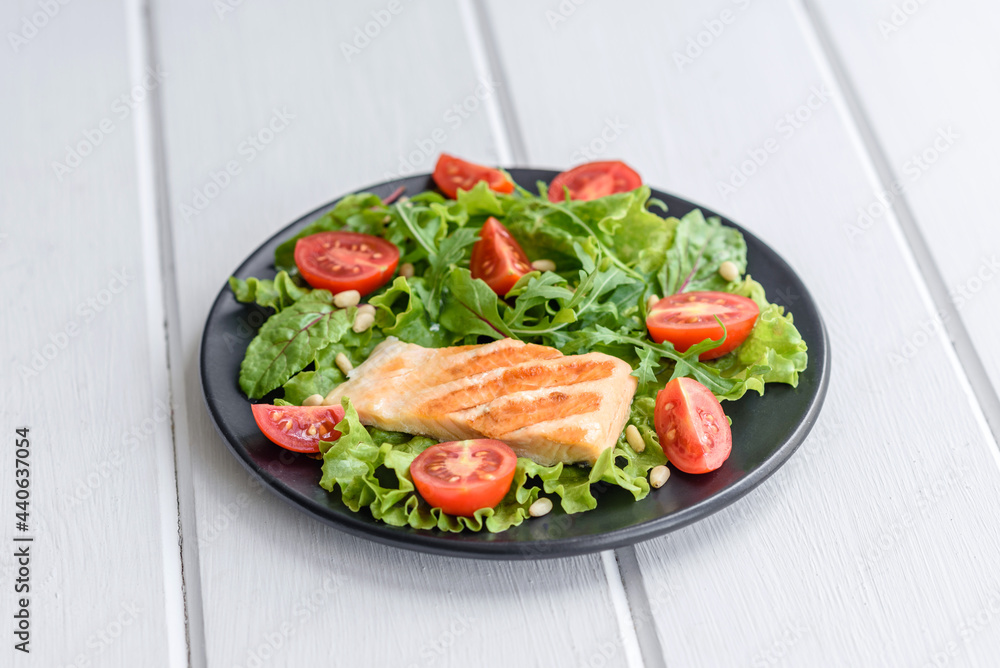 Delicious fresh salad with fish, tomatoes and lettuce leaves Delicious fresh salad with fish, tomatoes and lettuce leaves