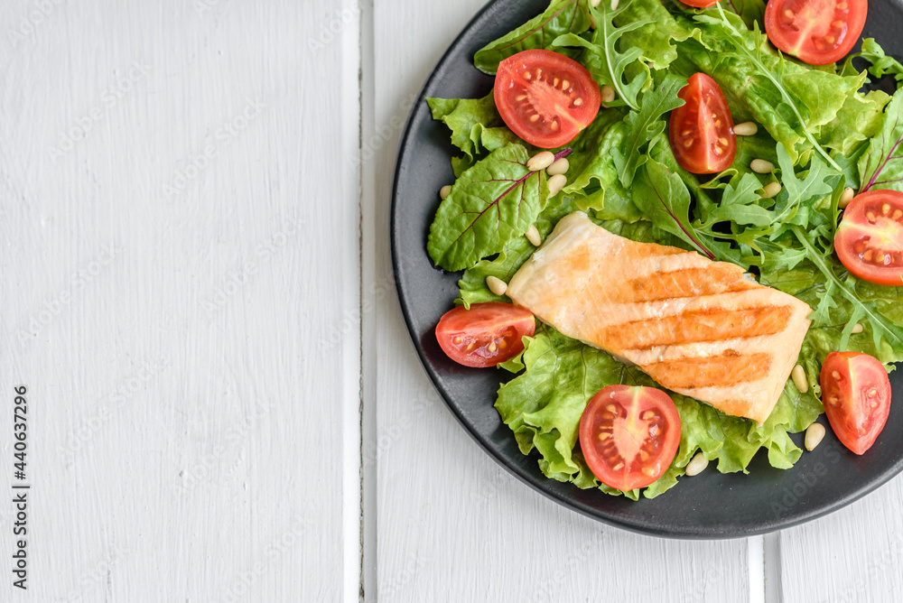 Delicious fresh salad with fish, tomatoes and lettuce leaves Delicious fresh salad with fish, tomatoes and lettuce leaves