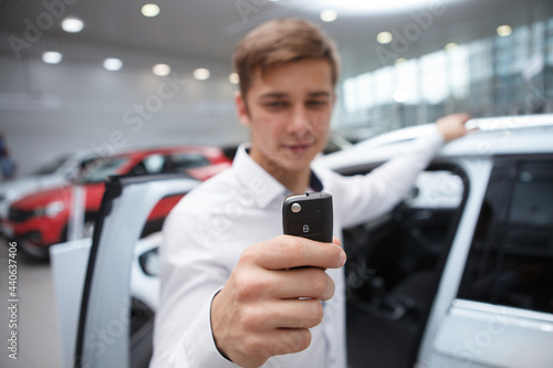 Selective focus on car key in the hand of male customer at car dealership
