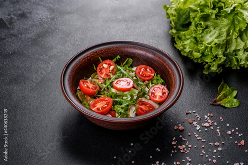 Pieces of chicken, tomatoes and lettuce leaves on a dark concrete background