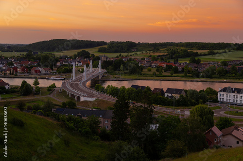 A scenic and picturesque view on the rolling hills of the Netherlands with in the foreground the Suspension bridge of the Belgium village Kanne during a nice sunset in summer. 