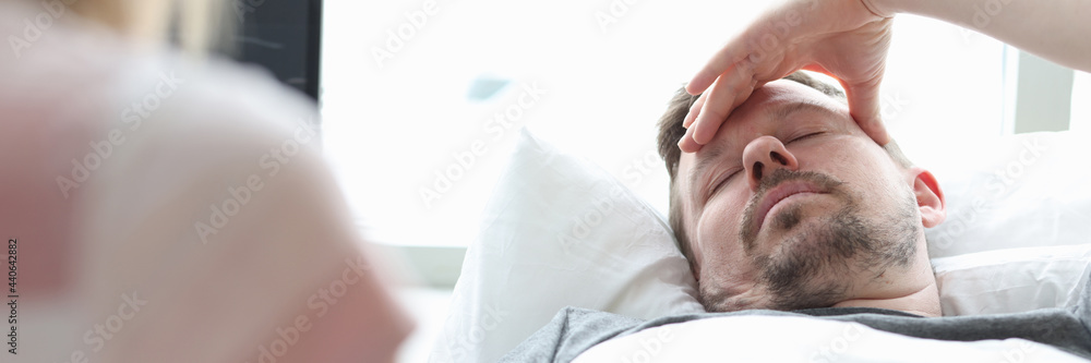 Naklejka premium Woman visitor holding hand of sick man in hospital room