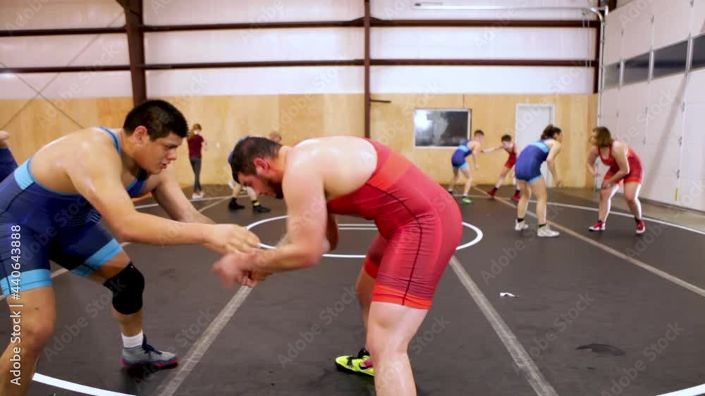 Pair Of Heavy Weight Wrestlers Drilling Takedowns During A Coed Group