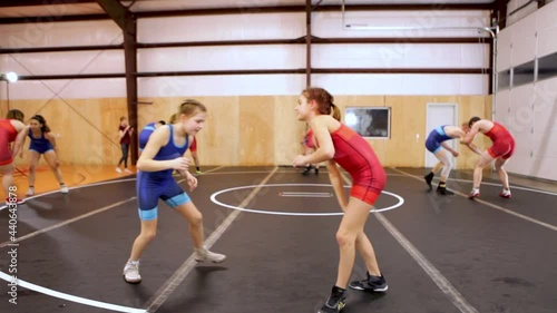 Pair of youth wrestlers drilling moves during a coed group wrestling practice. photo