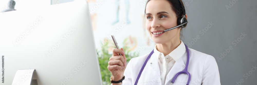 Doctor in headphones communicating with patient via video link Doctor in headphones communicating with patient via video link