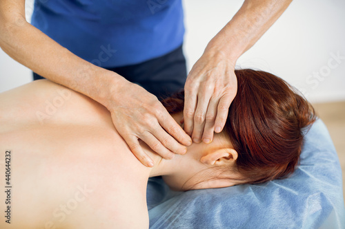 Young beautiful woman getting spa massage treatment. Neck massage concept. Woman physiotherapist giving neck massage to a woman patient in modern clinic