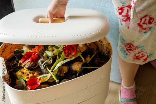 A woman opens a home composter, The zero waste concept, photo