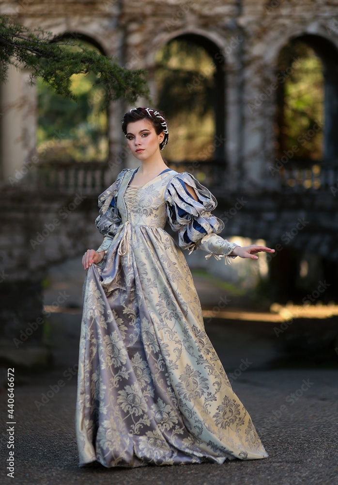 Beautiful girl with braided hair in medieval dress standing in front of ...
