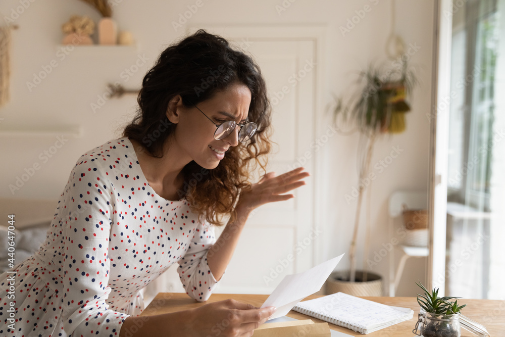 Angry woman in glasses reading letter, received bad news, sitting at desk, unhappy businesswoman working with correspondence, dissatisfied female holding document, dismissal or debt notification Angry woman in glasses reading letter, received bad news, sitting at desk, unhappy businesswoman working with correspondence, dissatisfied female holding document, dismissal or debt notification