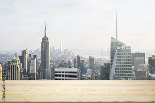 Blank wooden table top with beautiful New York skyline at daytime on background, mockup