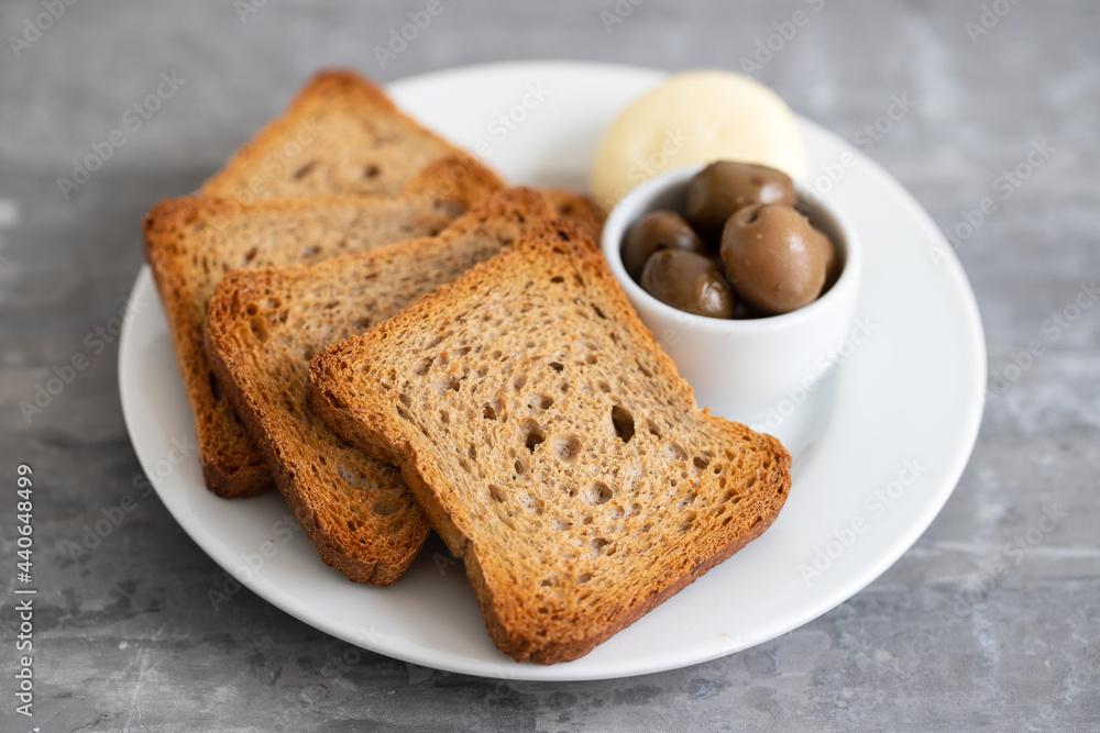 toasts with cheese and olives on the plate